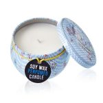 Open soy wax perfumed candle in a decorative light blue patterned tin with lid resting beside it